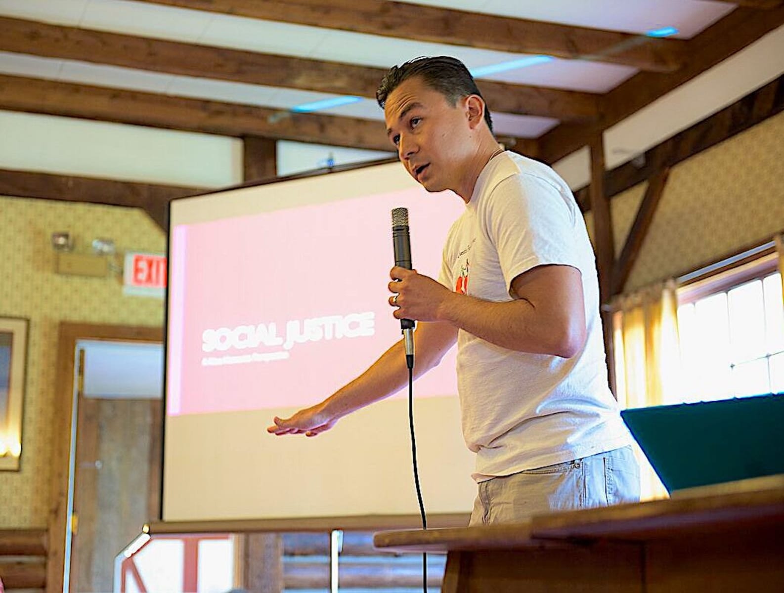 Person speaking about Social Justice at indoor meeting. Person speaking about Social Justice at indoor meeting.